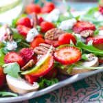 delicious Arugula salad topped with strawberries, goat cheese and toasted pecans then drizzled with a simple vinaigrette