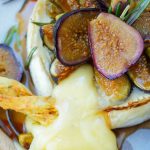 This delicious baked brie recipe is topped with roasted figs, honey, rosemary, and pistachios. The perfect easy appetizer that's ready in 25 minutes or less