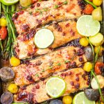 This delicious & easy Salmon Sheet Pan Dinner recipe is made in 30 minutes or less and has a sweet tangy sauce. Served with potatoes, asparagus, & tomatoes.