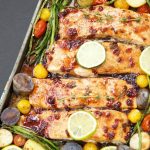 This delicious & easy Salmon Sheet Pan Dinner recipe is made in 30 minutes or less and has a sweet tangy sauce. Served with potatoes, asparagus, & tomatoes.