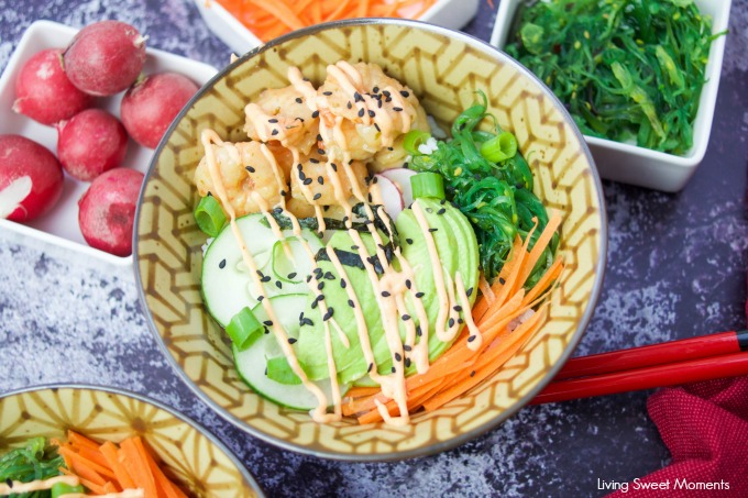 This delicious spicy shrimp poke bowl recipe is served with hot sushi rice, spicy mayo, avocados, radishes, and carrots. A quick weeknight dinner idea