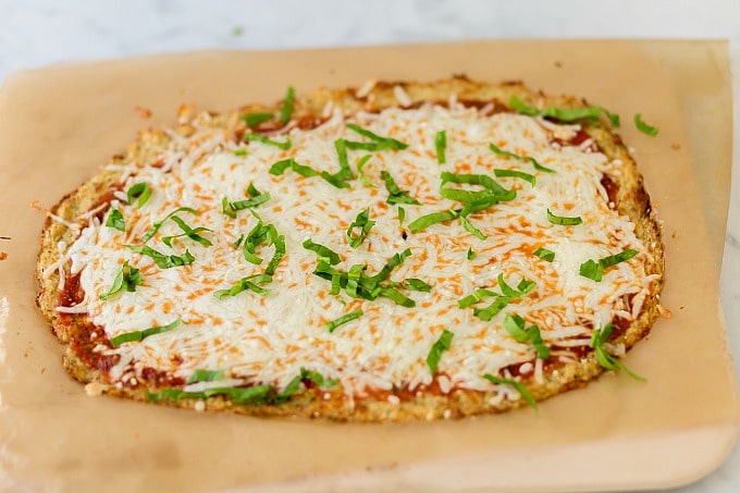 This keto friendly Cauliflower Pizza Crust is crispy, delicious, low-carb, and super easy to make. Top with your favorite sauce and veggies & it'll be a hit