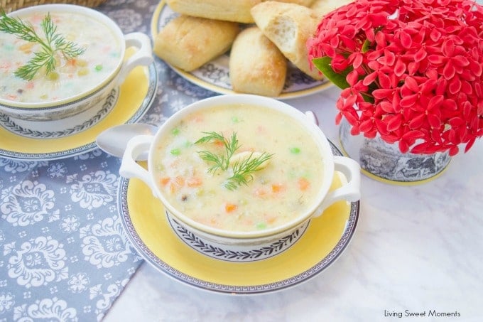 This creamy Potato Dumpling Soup recipe is the perfect hearty vegetarian soup for winter. 2 bowls of soup with red flowers and fresh baked rolls