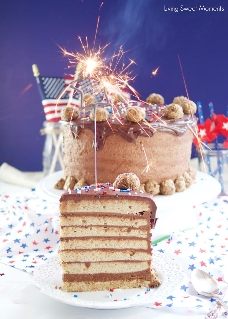 This colossal Peanut Butter Chocolate Cake recipe is made from scratch and there's a slice with a sparkler on top. Beautiful cake for celebrations