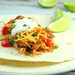 You won't believe how easy these Slow Cooker Shredded Chicken Tacos are to make. Serve in a warm tortilla with cheese, veggies, and sour cream