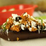 This tasty Greek Stuffed Eggplant is made with meat, kalamata olives and topped with feta cheese and tzatziki sauce. The perfect quick weeknight dinner idea
