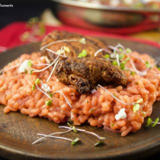Enjoy a creamy beet risotto recipe made with roasted beets, arborio rice & goat cheese served with crispy fire-grilled chicken. Served on a wooden plate and garnished with greens