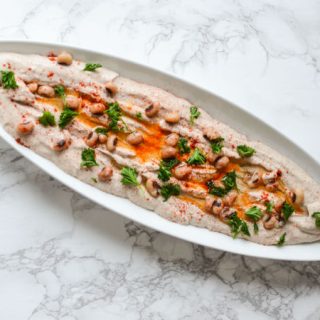 Entertain in style! This savory Black Eyed Pea Hummus recipe is the perfect appetizer to serve with pita chips and crackers. A delicious flavorful spread. Whole narrow white dish
